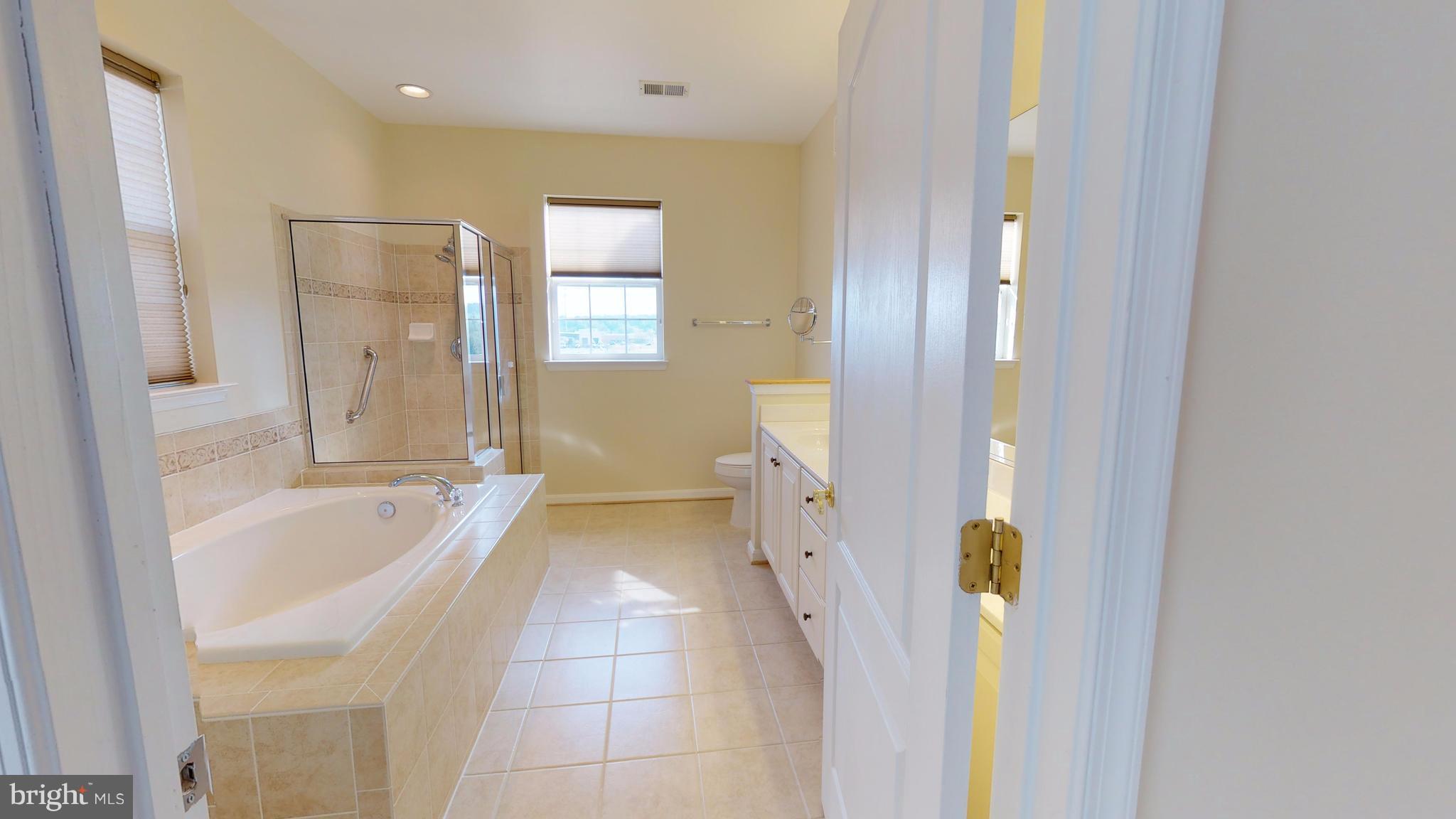 8601 Roaming Ridge Way, Unit 402 Odenton, MD 21113 - Photo 14 of 30 a bathroom with a tub sink and mirror