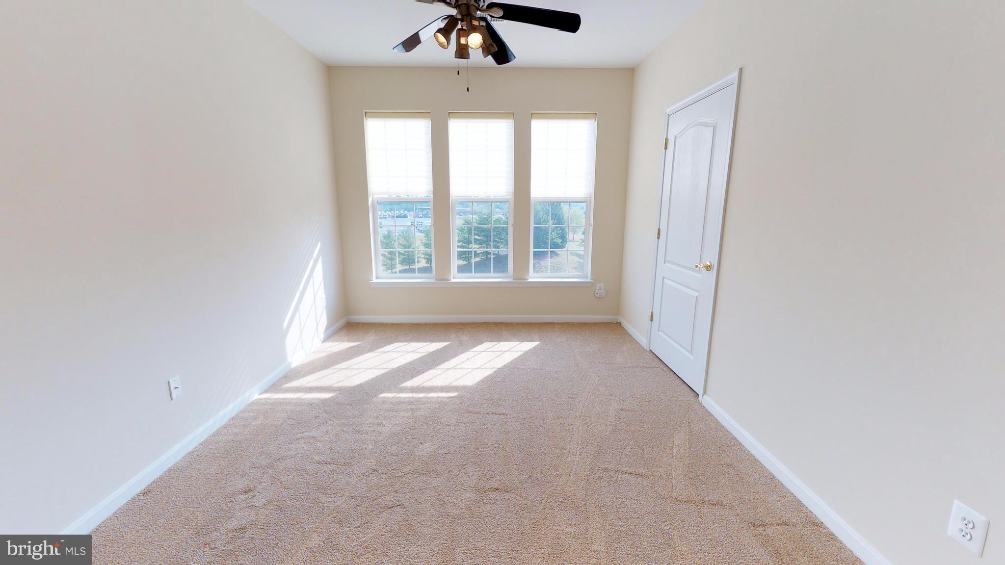 8601 Roaming Ridge Way, Unit 402 Odenton, MD 21113 - Photo 4 of 30 wooden floor in an empty room with a window