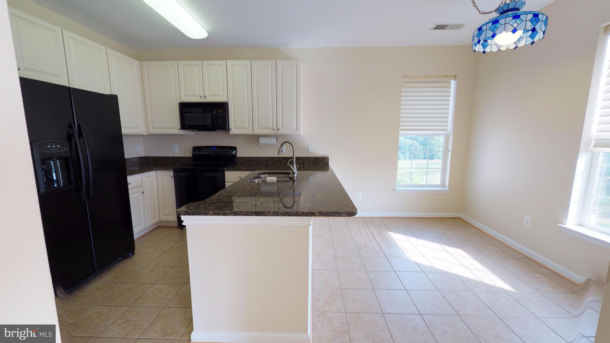 8601 Roaming Ridge Way, Unit 402 Odenton, MD 21113 - Photo 8 of 30 a kitchen with a stove a refrigerator and a sink