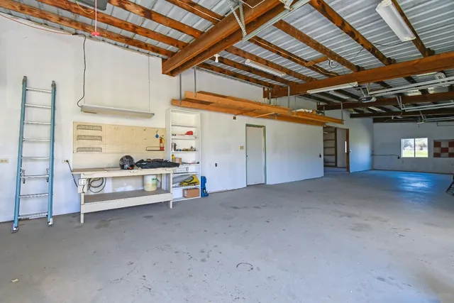 a view of a kitchen with a sink cabinet a ceiling fan and wooden floor