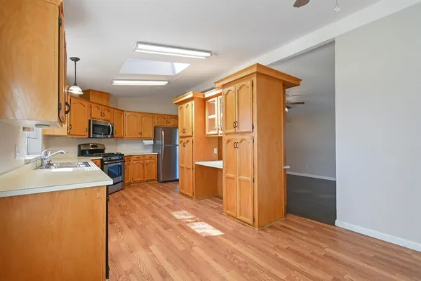 a kitchen that has a sink and a wooden floor