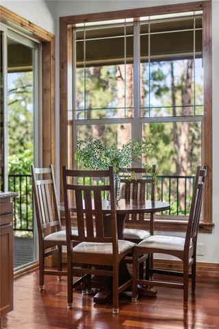 a view of a city from a dining room with wooden floor and windows