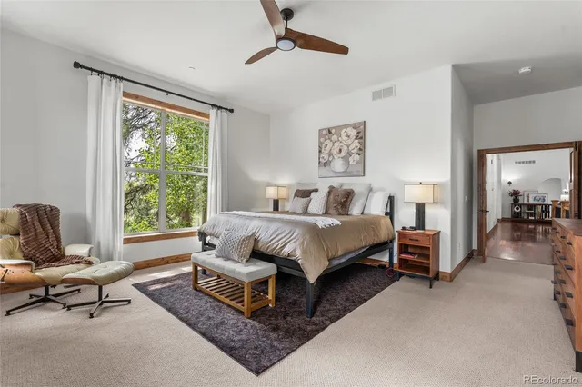 a bed sitting in a spacious bedroom next to a window