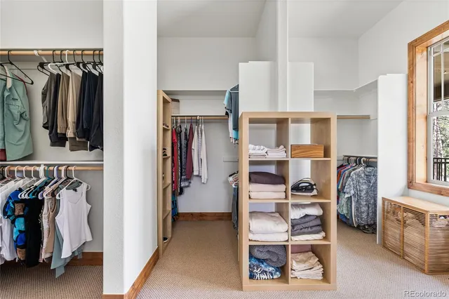 a view of walk in closet with clothes and shoes