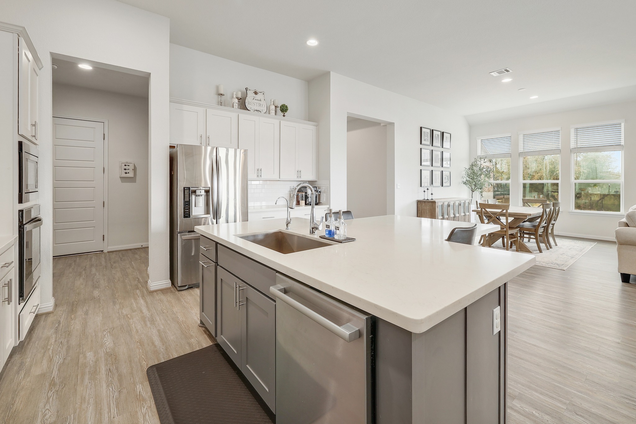 108 Argo Cove Georgetown, TX 78628 - Photo 36 of 36 Dual tone kitchen featuring stainless steel appliances, a kitchen island with sink, dual tone cabinets, recessed lighting, and open floor plan
