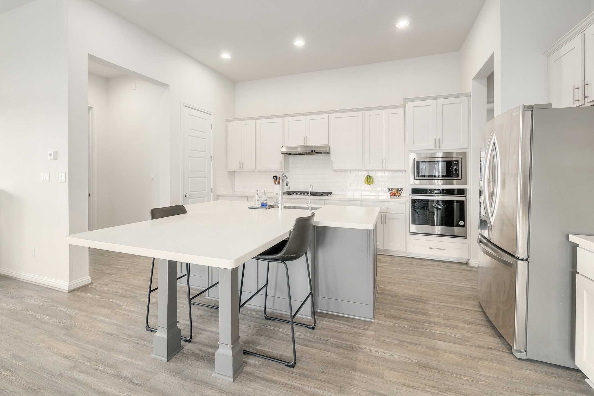108 Argo Cove Georgetown, TX 78628 - Photo 5 of 36 Kitchen featuring stainless steel appliances, a kitchen breakfast bar, white cabinetry, a center island with sink, and recessed lighting