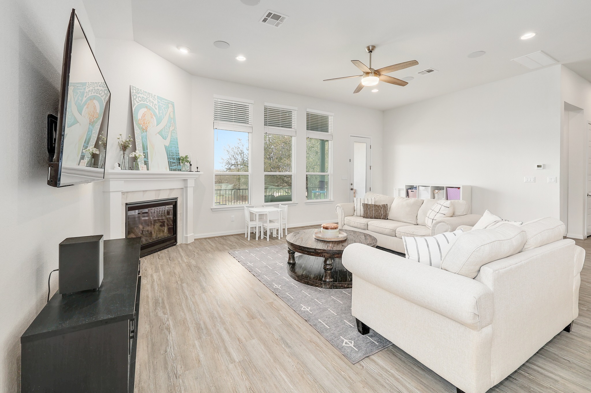 108 Argo Cove Georgetown, TX 78628 - Photo 6 of 36 Living room featuring ceiling fan, light wood finished floors, a tiled fireplace, and recessed lighting