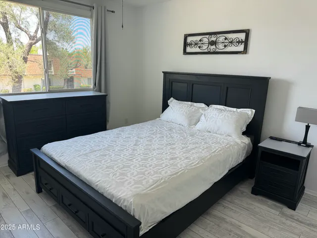 a large bed sitting in a bedroom next to a window