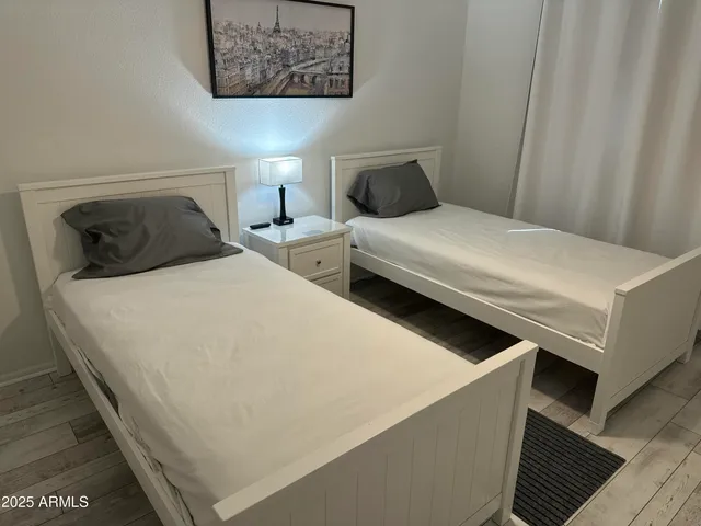 a bedroom with bed and a painting on the wall