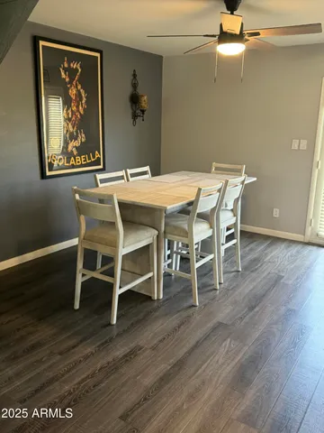 a dining room with wooden floor a chandelier a wooden table and chairs