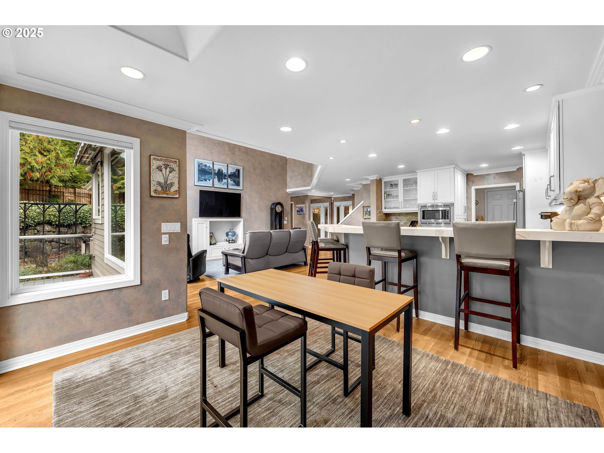 3496 Chaparrel Loop West Linn, OR 97068 - Photo 11 of 41 a open dining room with stainless steel appliances kitchen island granite countertop a dining table chairs and a refrigerator