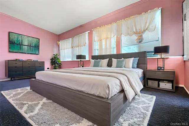 a bedroom with a bed a mirror and a flat tv screen on dresser