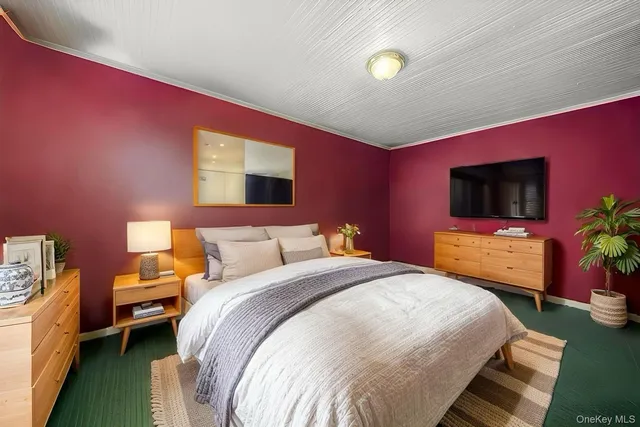 a bedroom with a bed and a flat screen tv