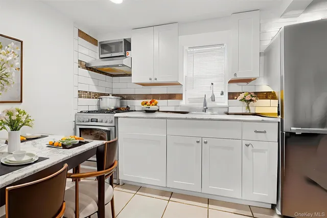 a kitchen with granite countertop white cabinets and appliances