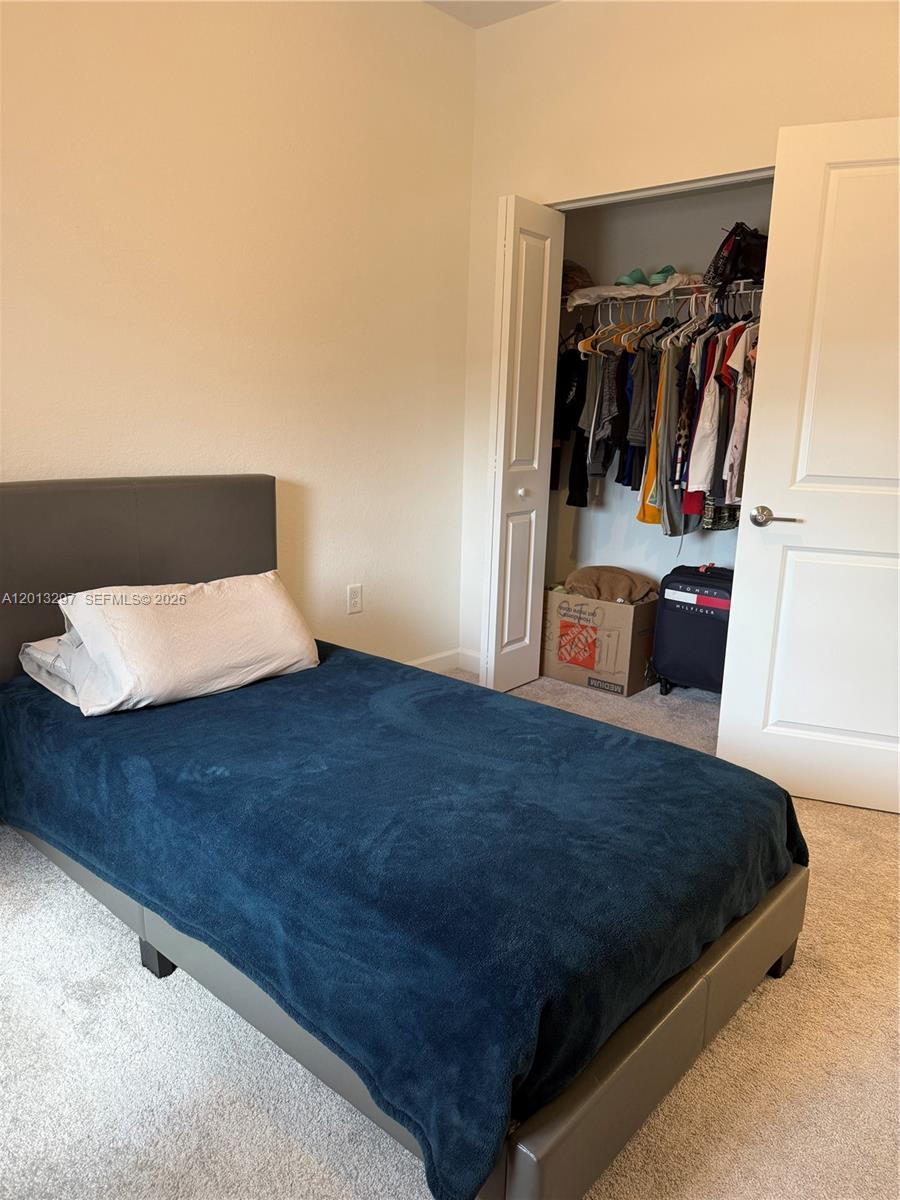 12955 Southwest 231st Terrace, Unit 12955 Miami, FL 33170 - Photo 18 of 26 a bedroom with a bed and a walk in closet