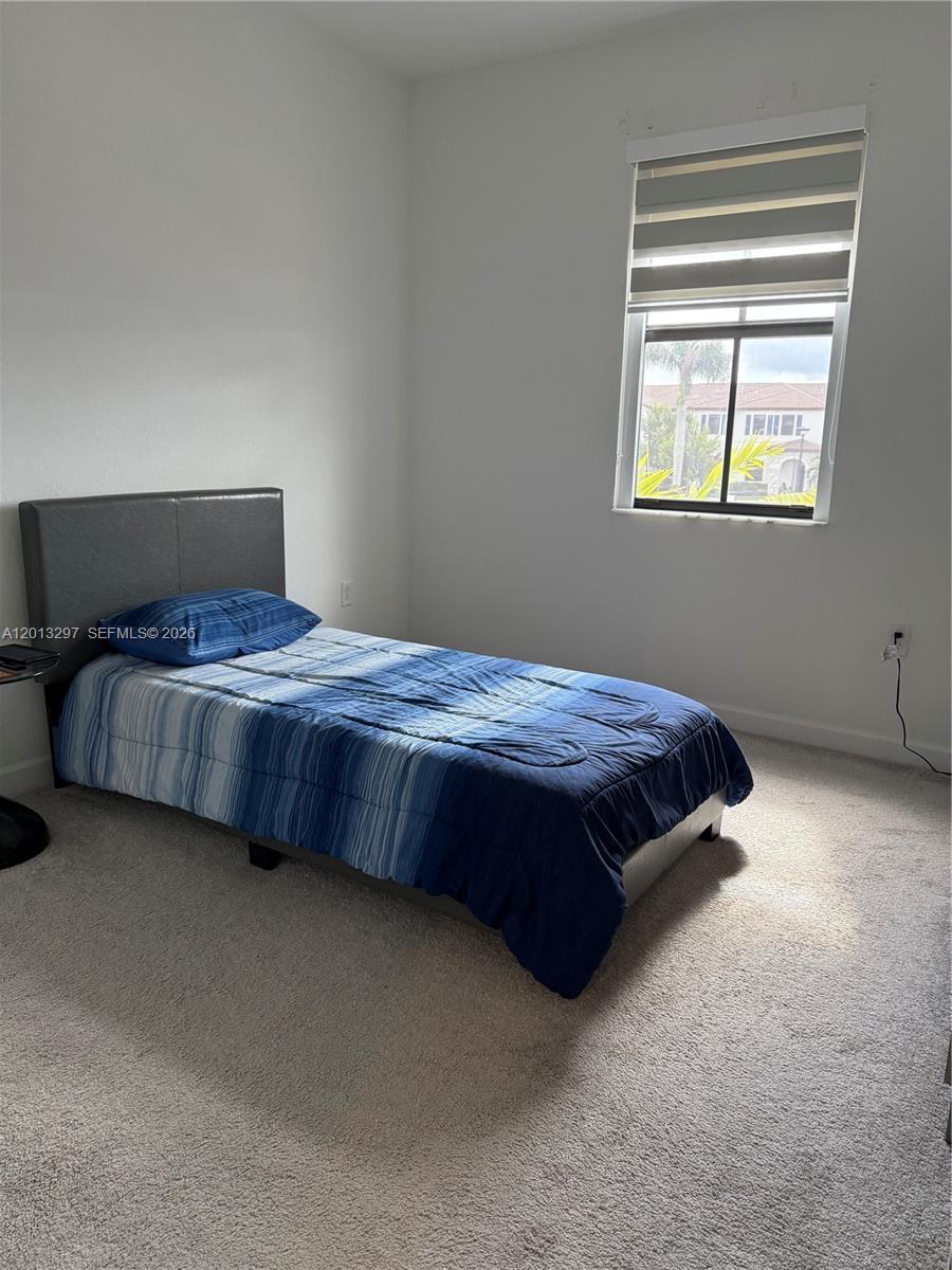 12955 Southwest 231st Terrace, Unit 12955 Miami, FL 33170 - Photo 20 of 26 a bedroom with a bed lamp and window