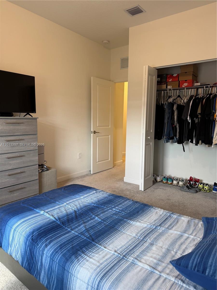 12955 Southwest 231st Terrace, Unit 12955 Miami, FL 33170 - Photo 21 of 26 a bedroom with a bed and a flat screen tv
