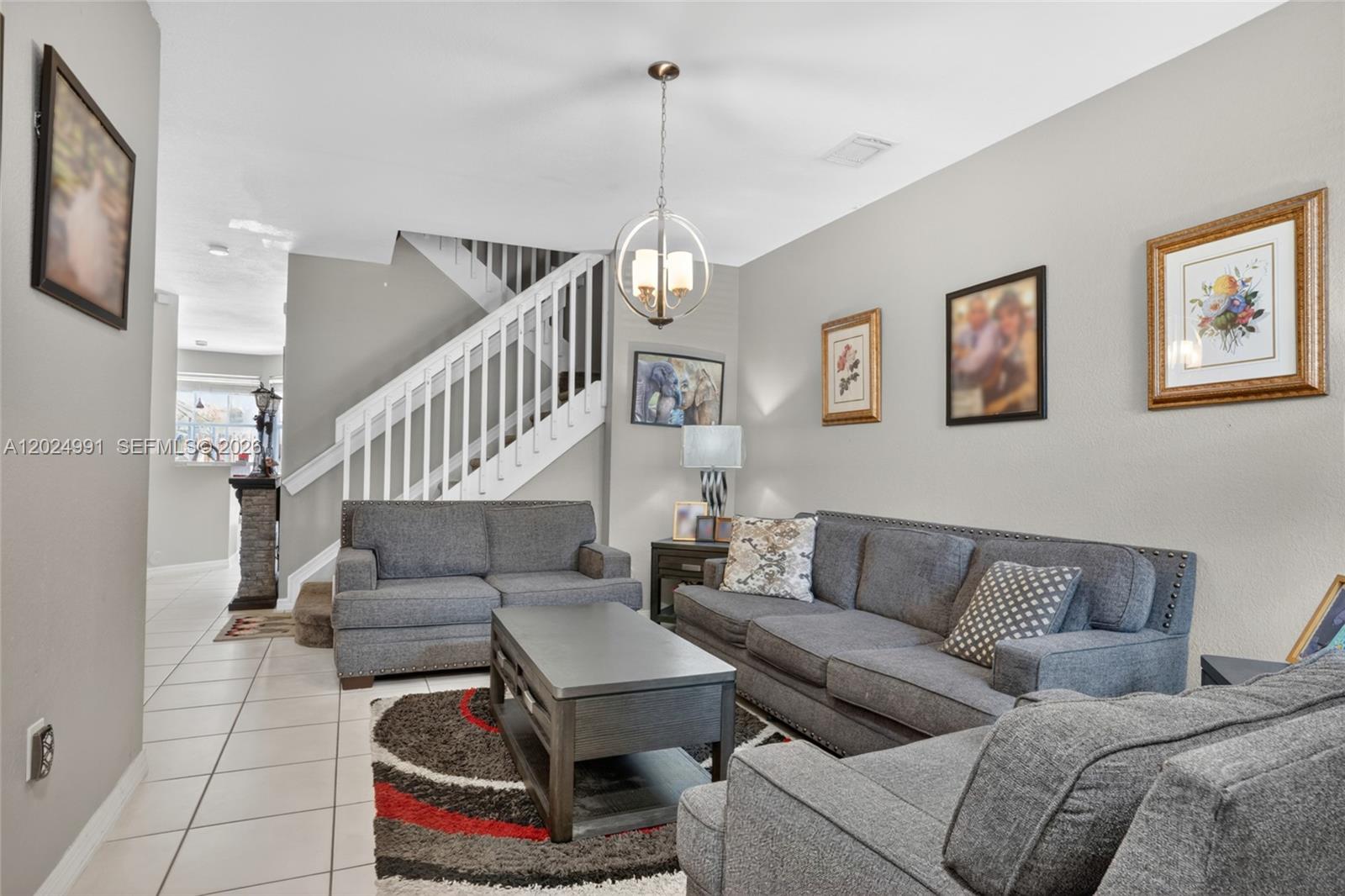 16651 Southwest 79th Terrace Miami, FL 33193 - Photo 5 of 34 a living room with furniture and a chandelier