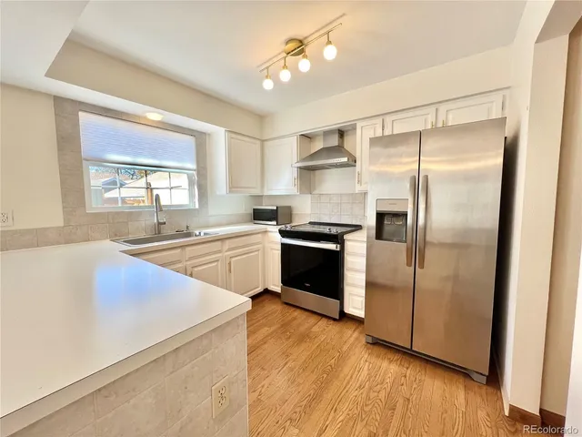 a kitchen with a refrigerator and a sink