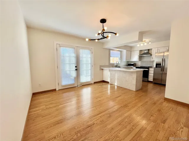 a large kitchen with cabinets wooden floor and stainless steel appliances