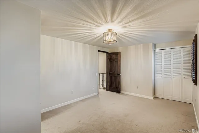 an empty room with a chandelier fan