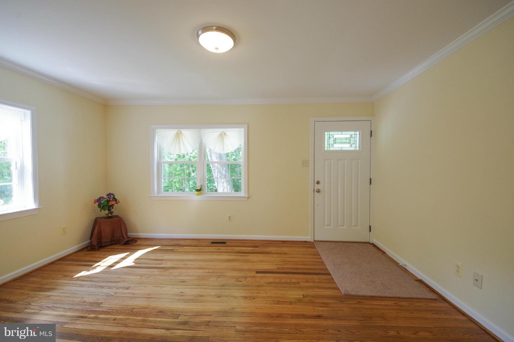 11505 Dewey Road Silver Spring, MD 20906 - Photo 9 of 29 an empty room with wooden floor and windows