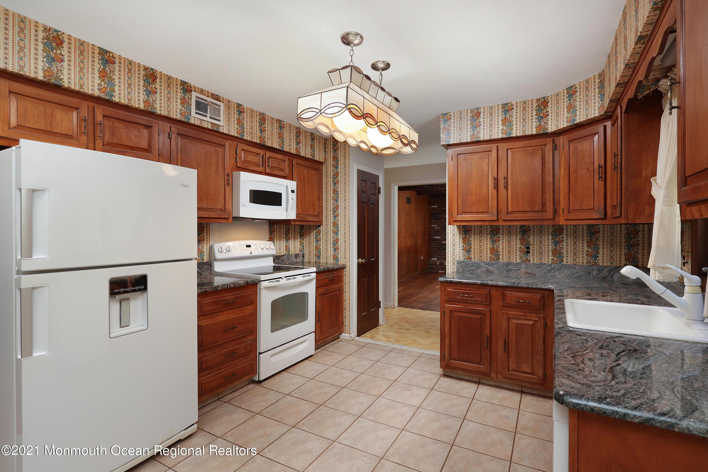 33 Woodhollow Road Colts Neck, NJ 07722 - Photo 22 of 36 a kitchen with granite countertop a refrigerator a stove a sink and dishwasher