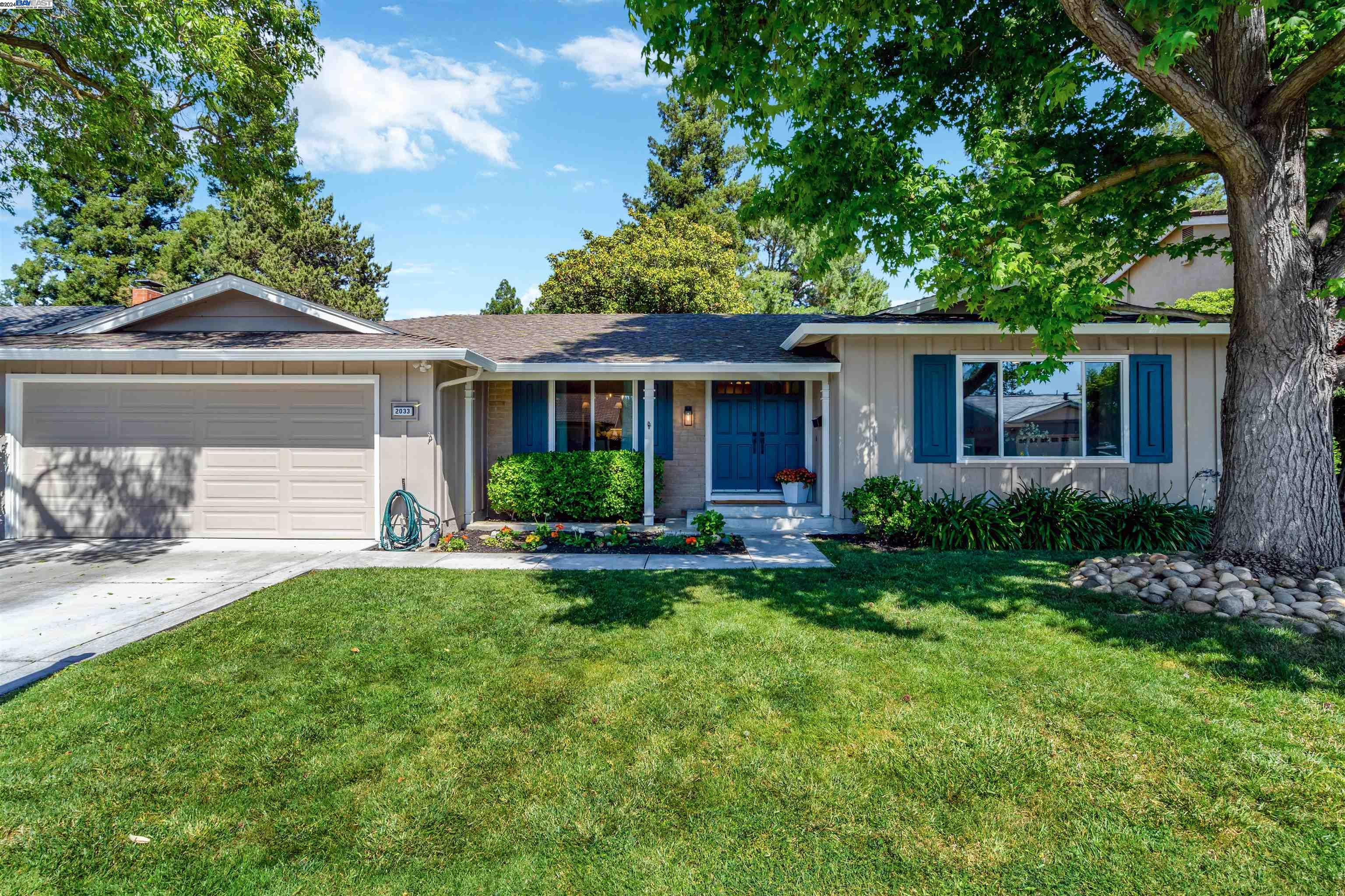 a front view of a house with a yard and trees
