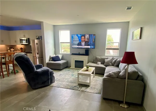 a living room with furniture a large window and a flat screen tv