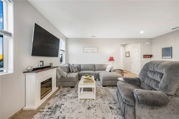 a living room with furniture a flat screen tv and a fireplace