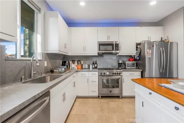 a kitchen with stainless steel appliances a sink cabinets and a refrigerator