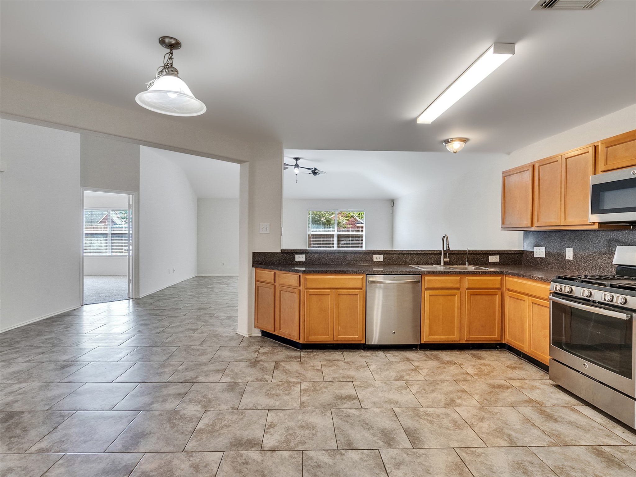 13431 Rural Oak Street Houston, TX 77034 - Photo 6 of 24 a large kitchen with granite countertop a stove a sink a counter space and cabinets