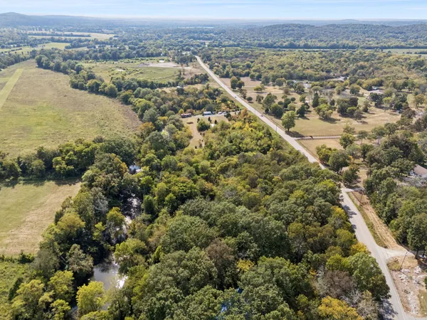 an aerial view of residential houses with outdoor space and lake view