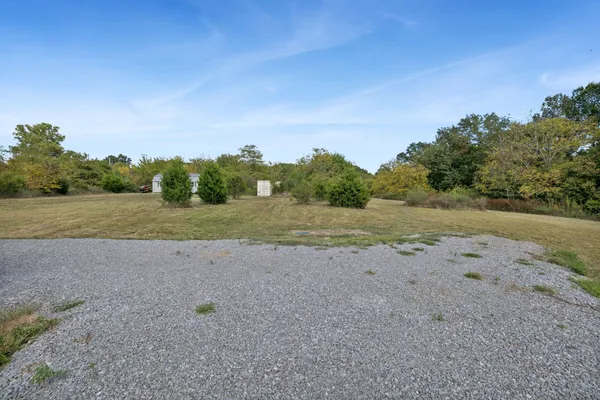 a view of a dirt road with a building in the background
