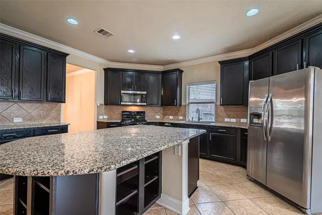 a kitchen with stainless steel appliances granite countertop a stove refrigerator and sink