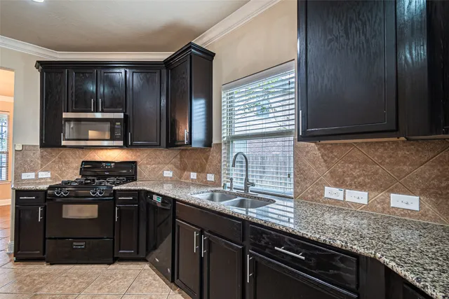 a kitchen with stainless steel appliances granite countertop wooden cabinets a stove top oven and granite counter tops