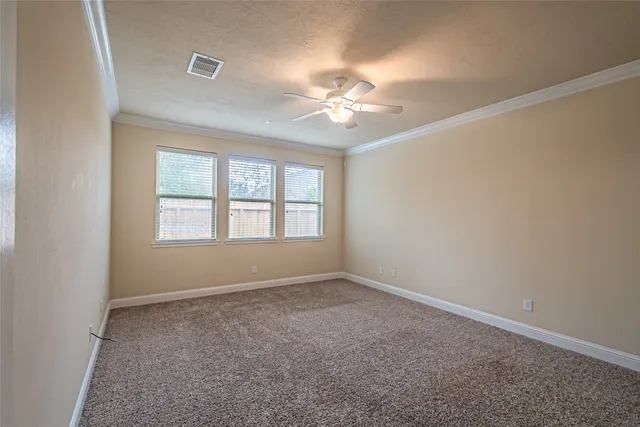 an empty room with a window and a ceiling fan
