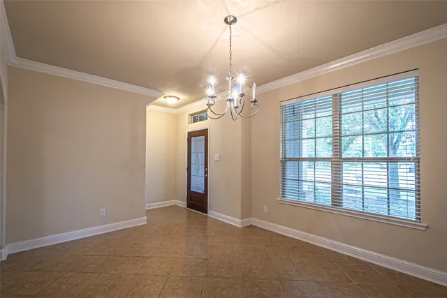 a view of a livingroom with a chandelier fan and windows