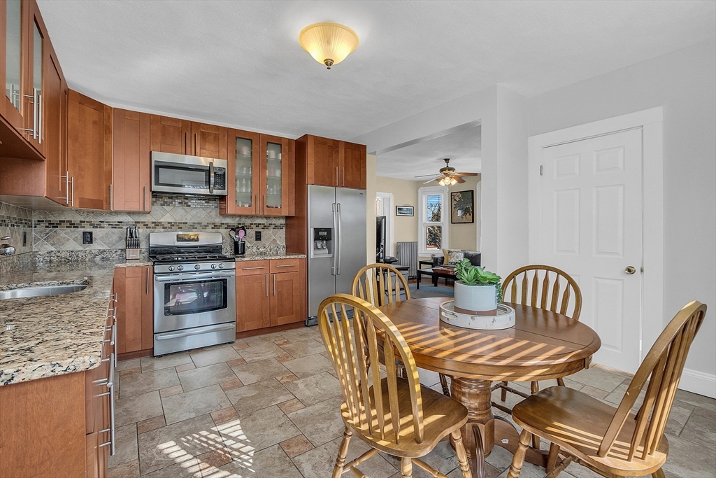 73 Orange Street, Unit 2 Waltham, MA 02453 - Photo 11 of 34 a kitchen with stainless steel appliances kitchen island granite countertop a sink and a refrigerator