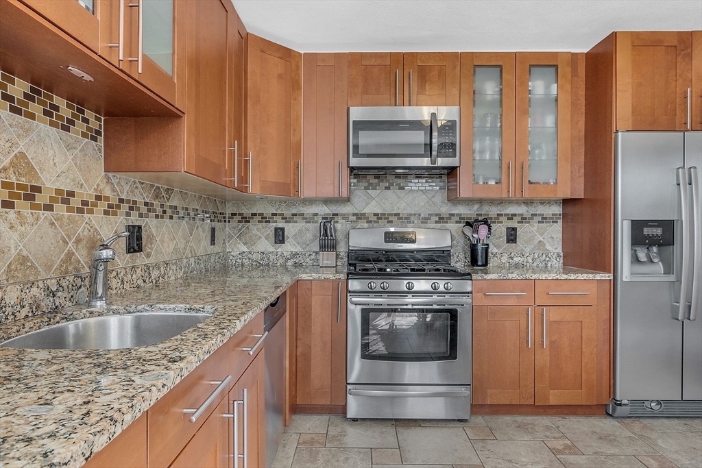 73 Orange Street, Unit 2 Waltham, MA 02453 - Photo 13 of 34 a kitchen with stainless steel appliances granite countertop a sink stove and refrigerator