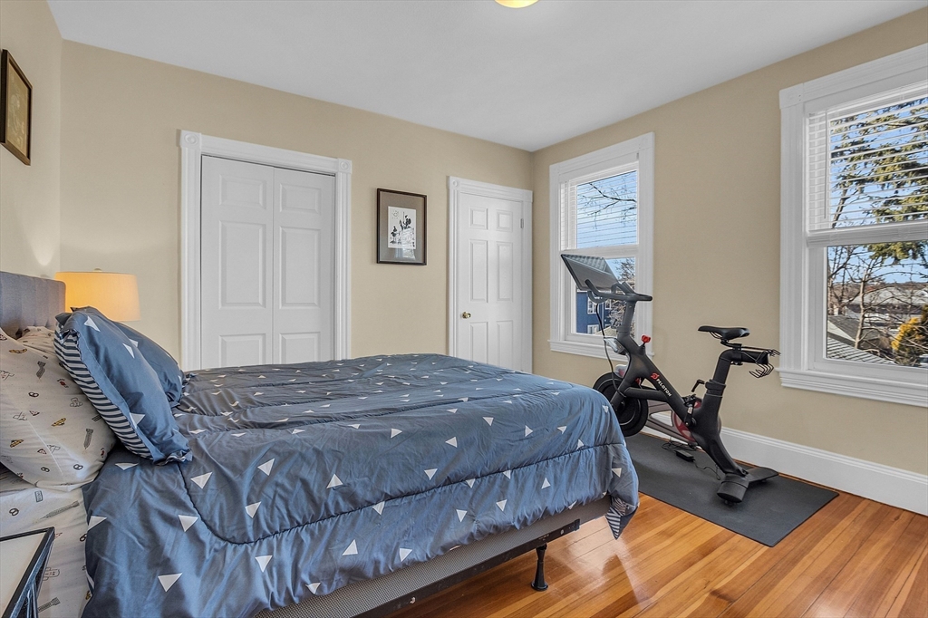 73 Orange Street, Unit 2 Waltham, MA 02453 - Photo 17 of 34 a bedroom with a bed and wooden floor