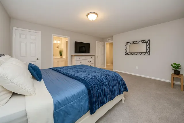 a bedroom with a large bed and a flat screen tv