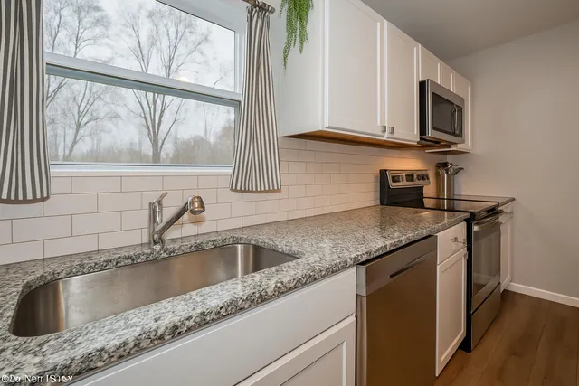 a kitchen with granite countertop a sink and a wooden floor