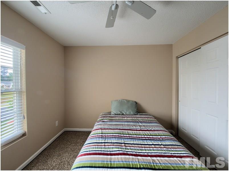2647 Quarry Ridge Lane Raleigh, NC 27610 - Photo 12 of 18 a bedroom with a bed and wooden floor