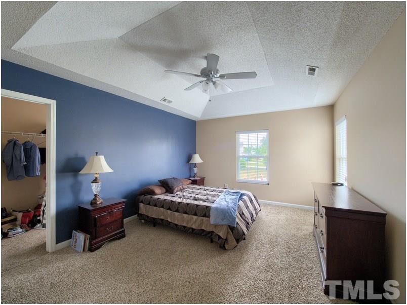 2647 Quarry Ridge Lane Raleigh, NC 27610 - Photo 14 of 18 a spacious bedroom with a bed and a flat screen tv