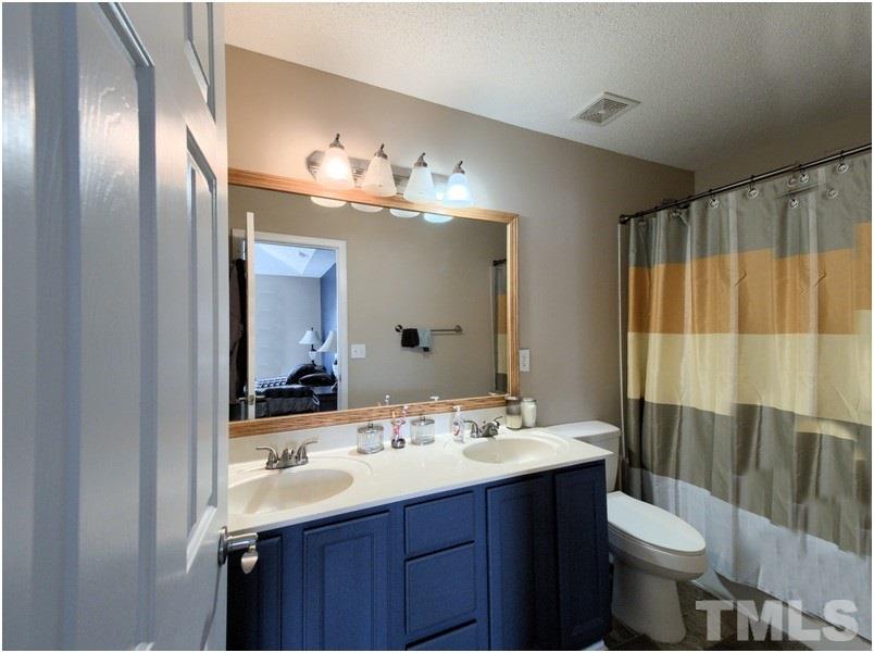 2647 Quarry Ridge Lane Raleigh, NC 27610 - Photo 16 of 18 a bathroom with a double vanity sink toilet and a mirror