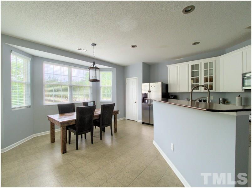 2647 Quarry Ridge Lane Raleigh, NC 27610 - Photo 5 of 18 a kitchen with granite countertop cabinets chairs dining table and stainless steel appliances