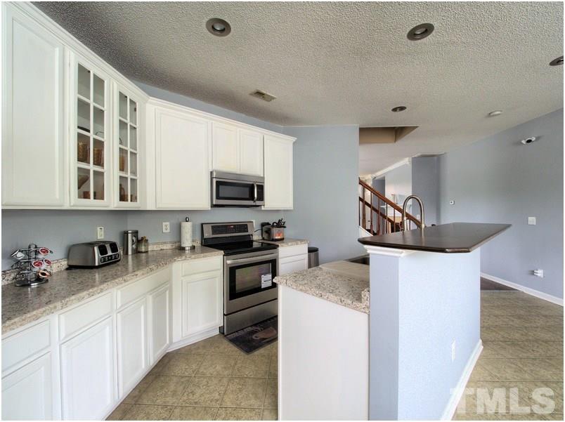 2647 Quarry Ridge Lane Raleigh, NC 27610 - Photo 7 of 18 a kitchen with stainless steel appliances a sink a stove and microwave