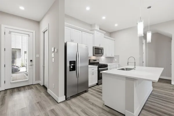 a kitchen with stainless steel appliances granite countertop a sink stove and refrigerator