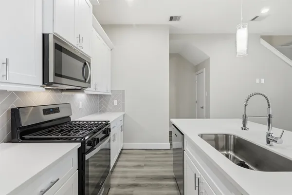 a view of a kitchen with a sink and a refrigerator